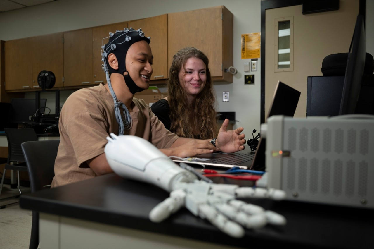 NKU Engineering majors in the lab programming a robotic arm.